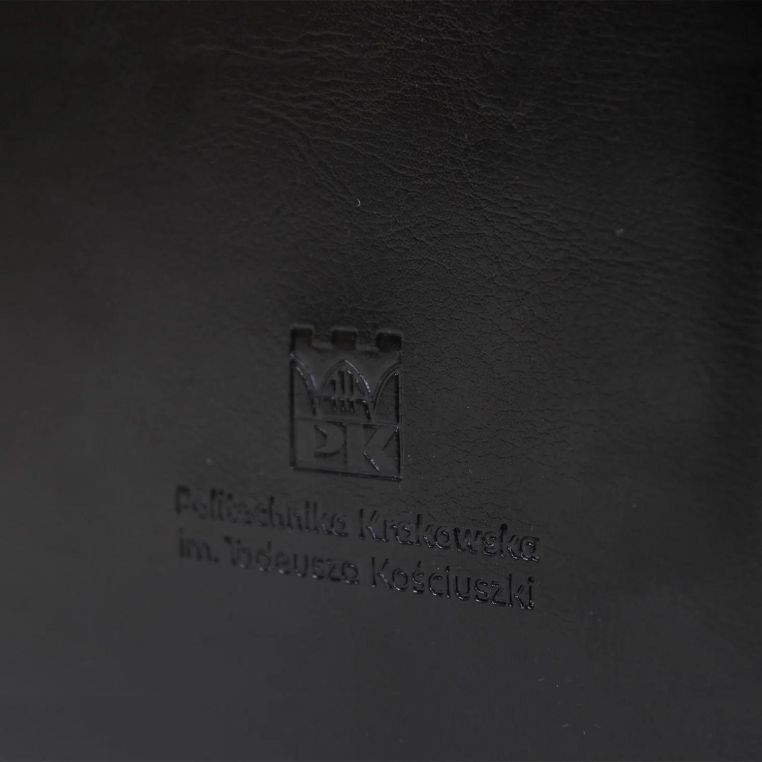 Okładka na dyplom z ekoskóry - Sklep Politechniki Krakowskiej Okładka na dyplom z ekoskóry czarna z logo Politechniki Krakowskiej - zbliżenie na logo